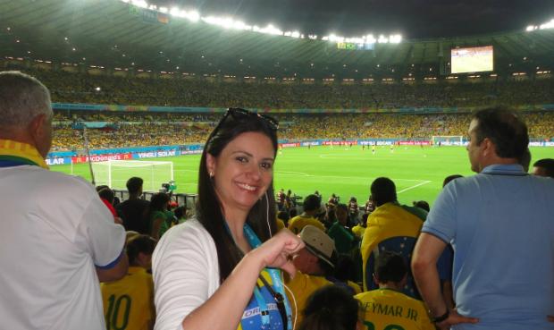 Mesmo sorridente, a jornalista Pollyanna Andrade faz sinal negativo atrás do gol de Júlio César