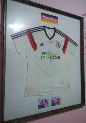 Com as manchas do treino de um ano atrás preservadas, camisa que Damião ganhou de Neuer foi parar em um quadro