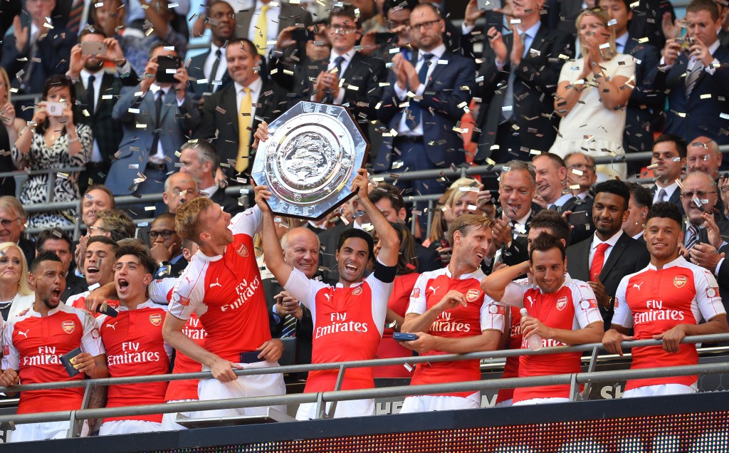 Arsenal's Spanish midfielder Mikel Arteta (C) lifts the trophy as Arsenal players celebrate after beating Chelsea in the FA Community Shield football match between Arsenal and Chelsea at Wembley Stadium in north London on August 2, 2015. Arsenal won the game 1-0. AFP PHOTO / GLYN KIRK  -- NOT FOR MARKETING OR ADVERTISING USE / RESTRICTED TO EDITORIAL USE --