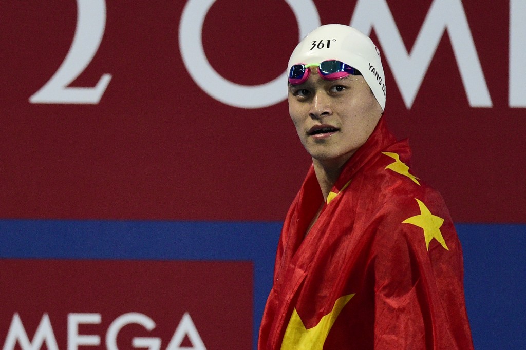 China's Sun Yang celebrates with his flag winning the final of the men's 800m freestyle swimming event at the 2015 FINA World Championships in Kazan on August 5, 2015.  AFP PHOTO / MARTIN BUREAU