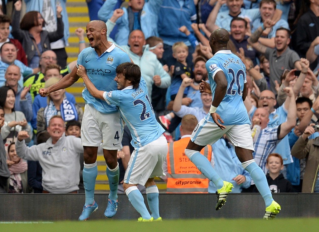 Manchester City's Belgian defender Vincent Kompany (L) celebrates with Manchester City's Spanish midfielder David Silva (2nd L) after scoring their second goal the English Premier League football match between Manchester City and Chelsea at The Etihad stadium in Manchester, north west England on August 16, 2015. AFP PHOTO / OLI SCARFF RESTRICTED TO EDITORIAL USE. No use with unauthorized audio, video, data, fixture lists, club/league logos or 'live' services. Online in-match use limited to 75 images, no video emulation. No use in betting, games or single club/league/player publications.