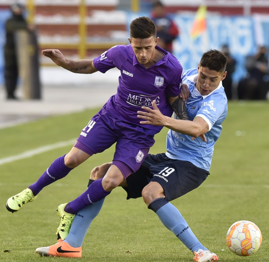 Footballer Brian Lozano (L) of Uruguay's Defensor Sporting vies for the ball with Nelson Cabrera of Bolivia's Bolivar, during their Copa Sudamericana match at the Hernando Siles Stadium, in La Paz, on August 18, 2015. AFP PHOTO / AIZAR RALDES