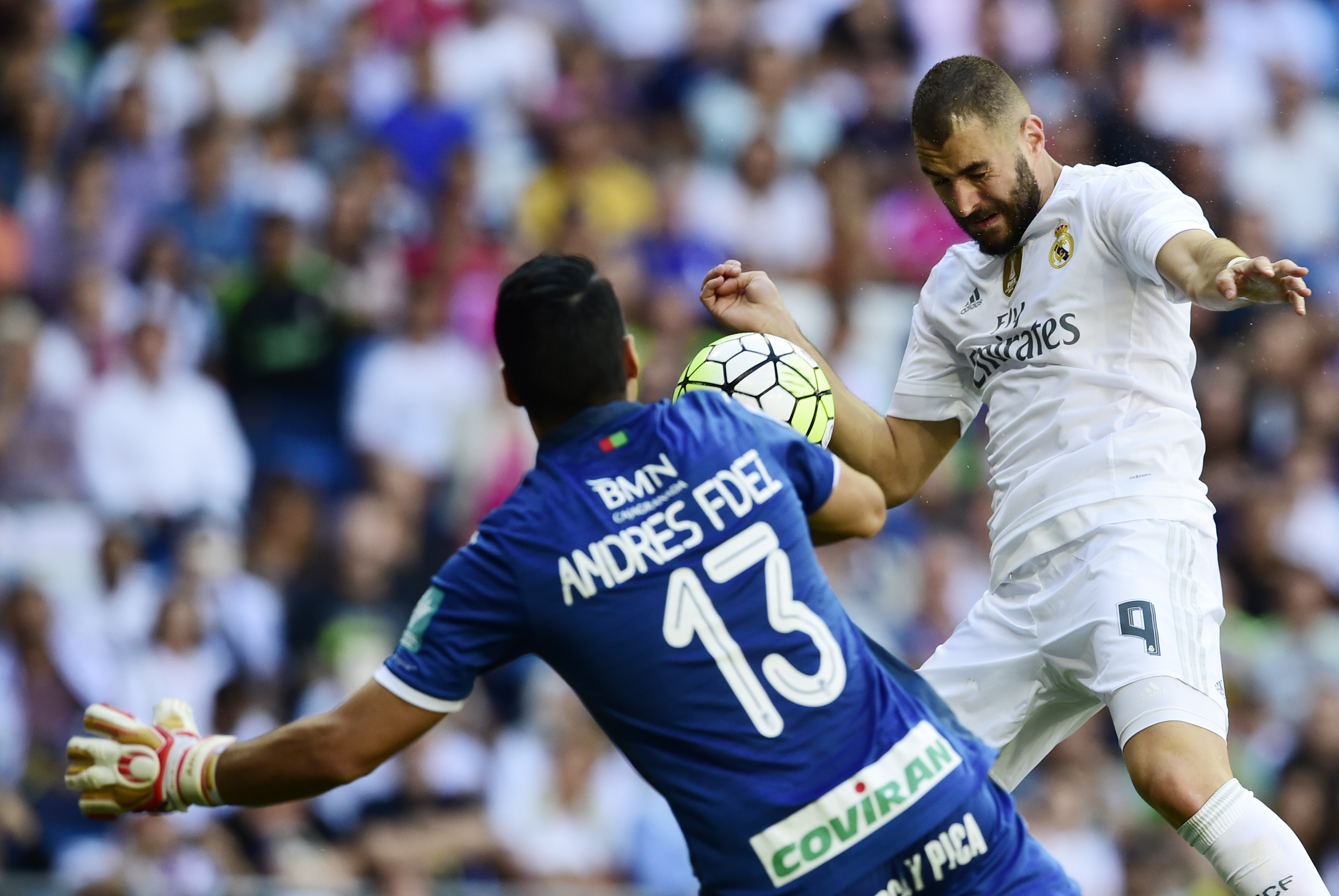 Real Madrid's French forward Karim Benzema (R) heads the ball to score during the Spanish league football match Real Madrid CF vs Granada FC at the Santiago Bernabeu stadium in Madrid on Spetember 19, 2015. AFP PHOTO/ JAVIER SORIANO