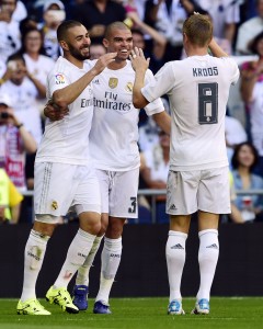 Real Madrid's French forward Karim Benzema (L) celebrates with Real Madrid's Portuguese defender Pepe (C) and Real Madrid's German midfielder Toni Kroos after scoring a goal during the Spanish league football match Real Madrid CF vs Granada FC at the Santiago Bernabeu stadium in Madrid on Spetember 19, 2015. AFP PHOTO/ JAVIER SORIANO