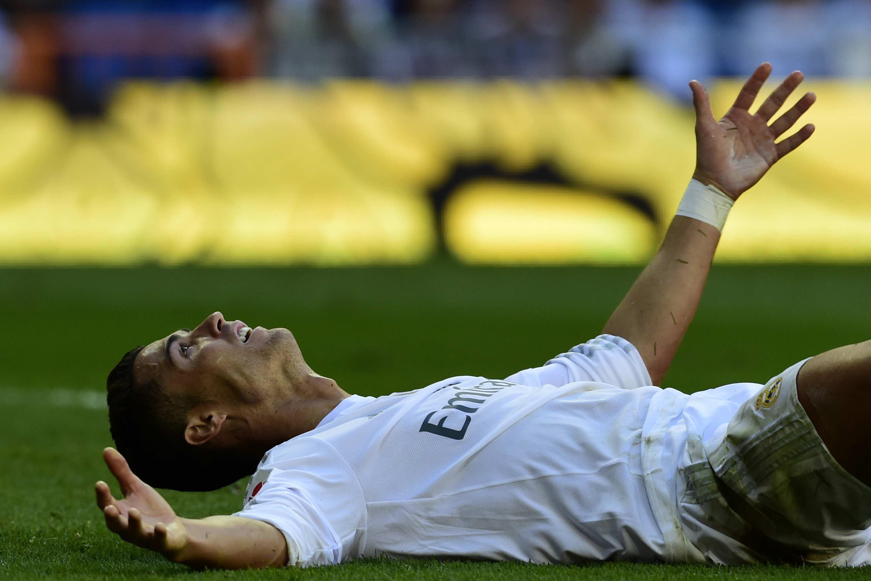 Real Madrid's Portuguese forward Cristiano Ronaldo reacts as he lies on the pitch during the Spanish league football match Real Madrid CF vs Granada FC at the Santiago Bernabeu stadium in Madrid on Spetember 19, 2015. AFP PHOTO/ JAVIER SORIANO