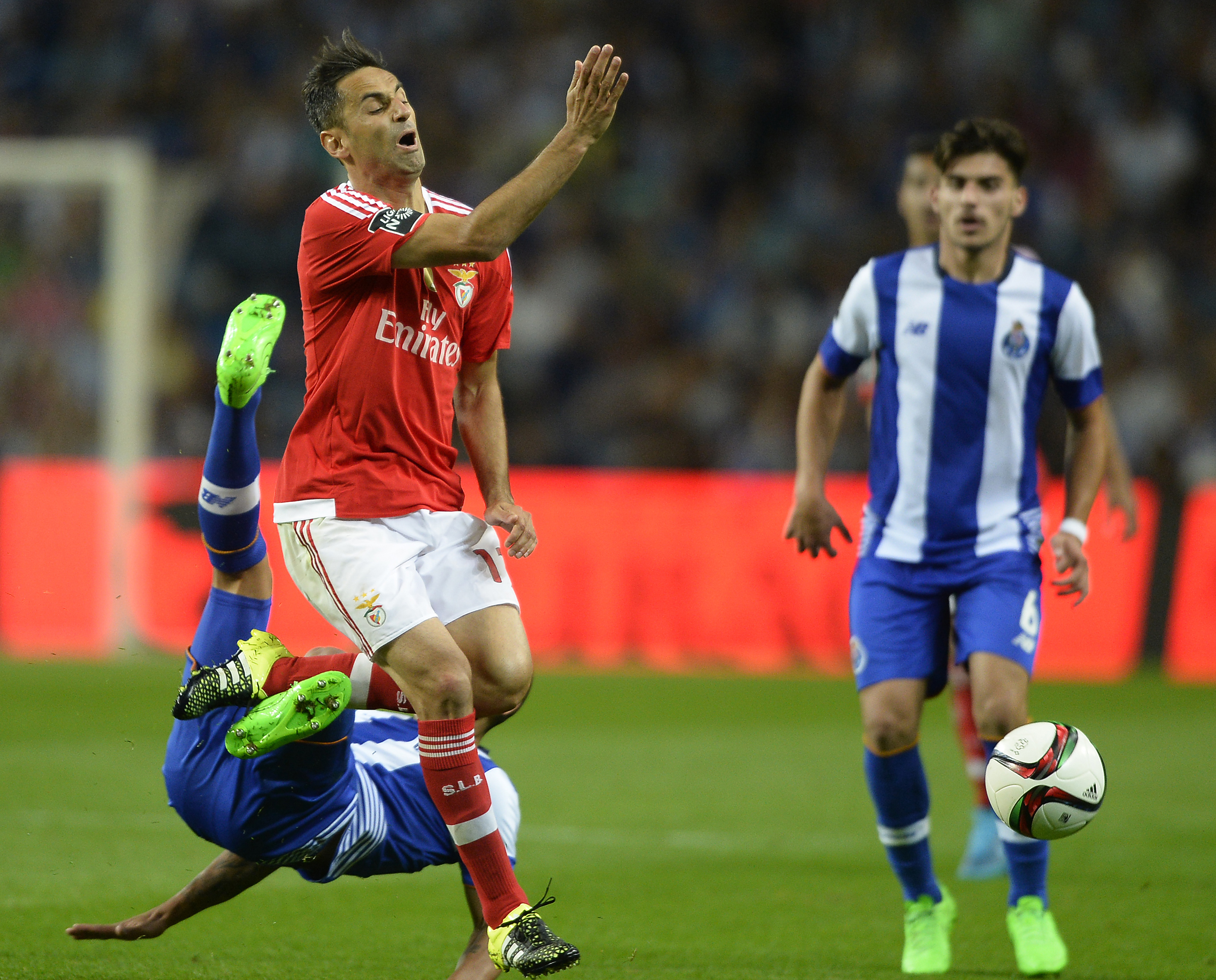 Benfica's Brazilian forward Jonas (C) vies with Porto's Uruguayan defender Maxi Pereira (L) during the Portuguese league football match FC Porto vs SL Benfica at the Dragao stadium in Porto, on September 20, 2015. AFP PHOTO/ MIGUEL RIOPA