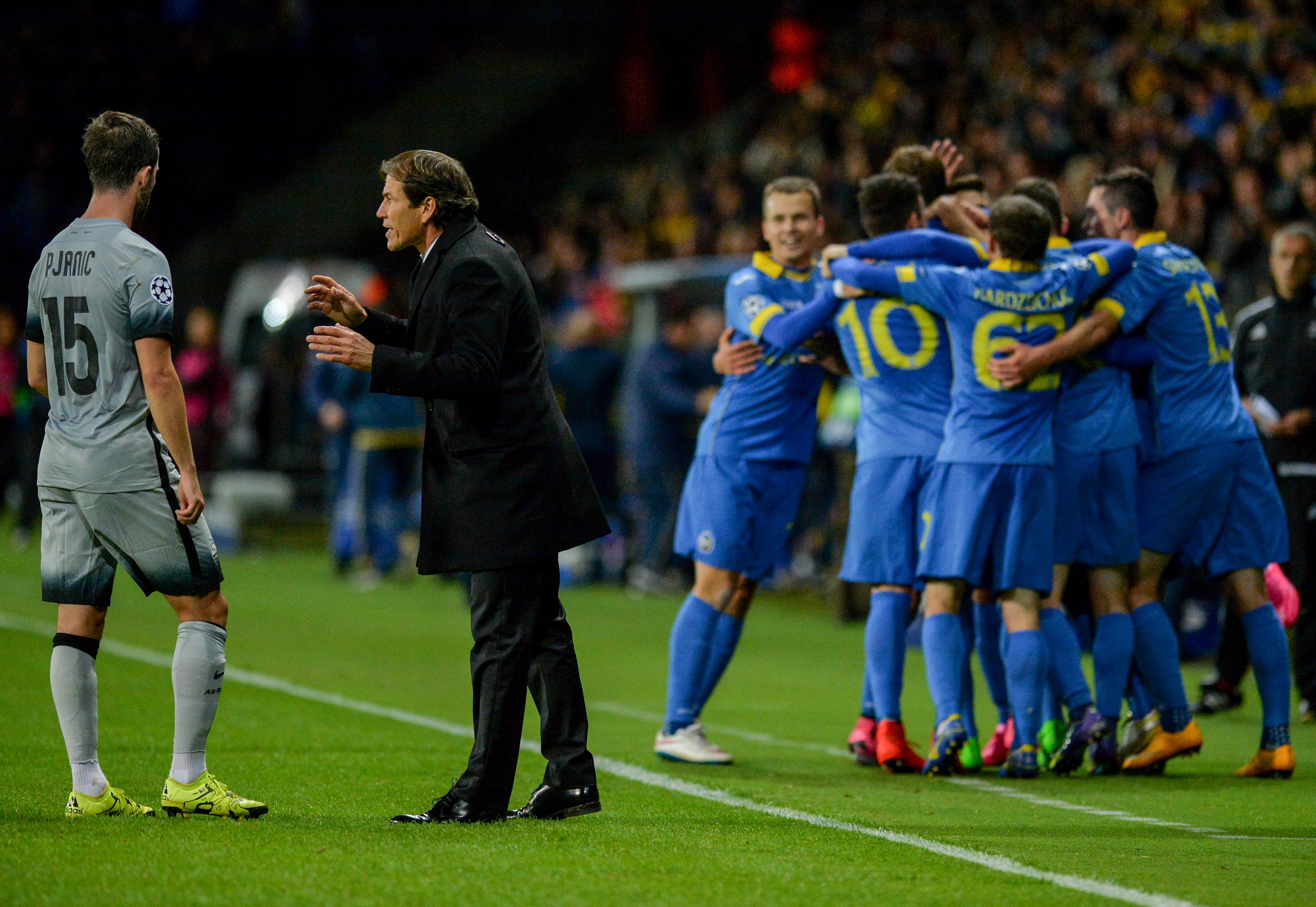 Roma's French coach Rudi Garcia (C) gives instructions to his player as BATE's players celebrate a goal during the UEFA Champions League group E football match between FC BATE Borisov and AS Roma at the Borisov-Arena in Borisov outside Minsk on September 29, 2015. AFP PHOTO / MAXIM MALINOVSKY
