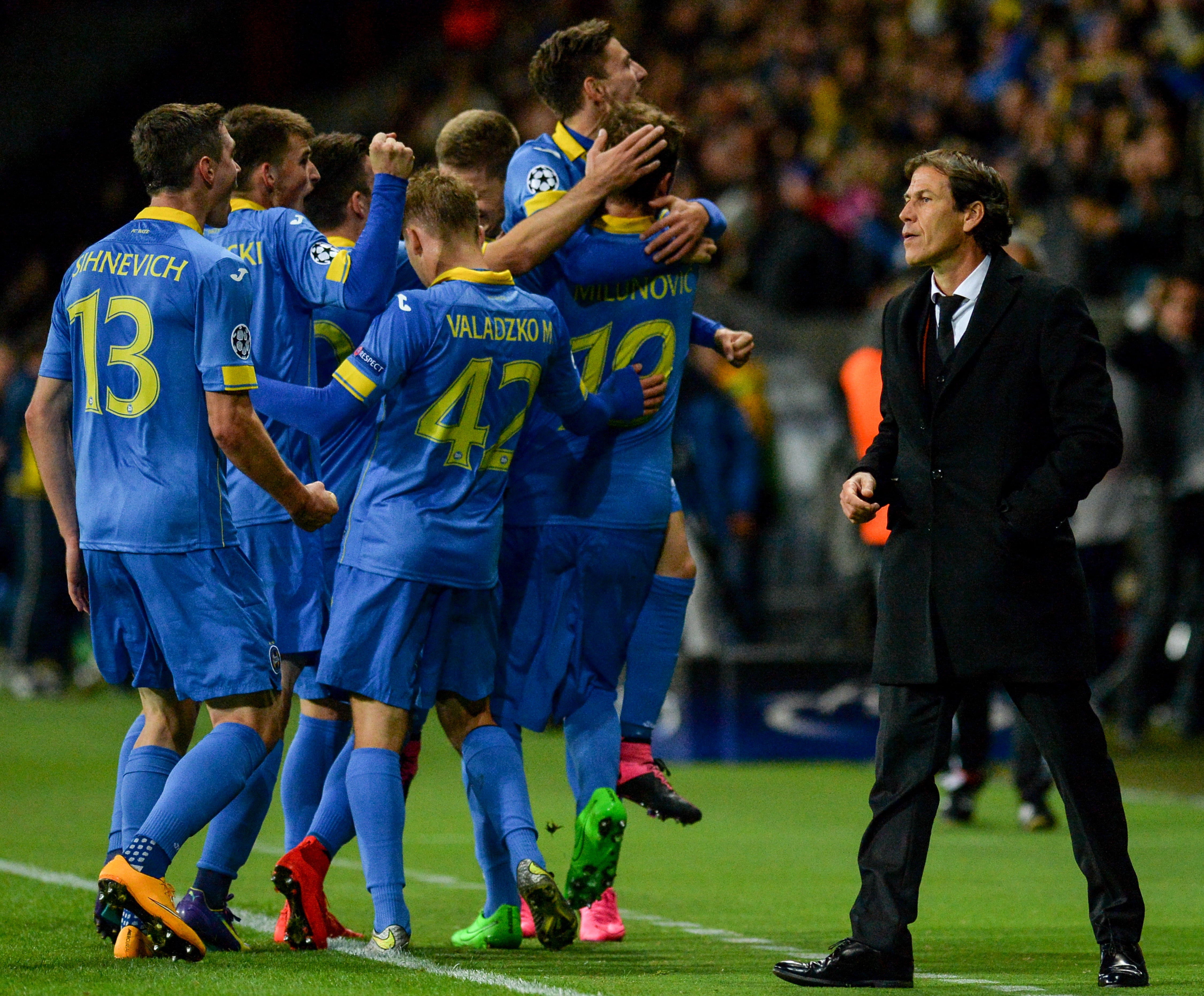 Roma's French coach Rudi Garcia (R) looks on as BATE's players celebrate a goal during the UEFA Champions League group E football match between FC BATE Borisov and AS Roma at the Borisov-Arena in Borisov outside Minsk on September 29, 2015. AFP PHOTO / MAXIM MALINOVSKY