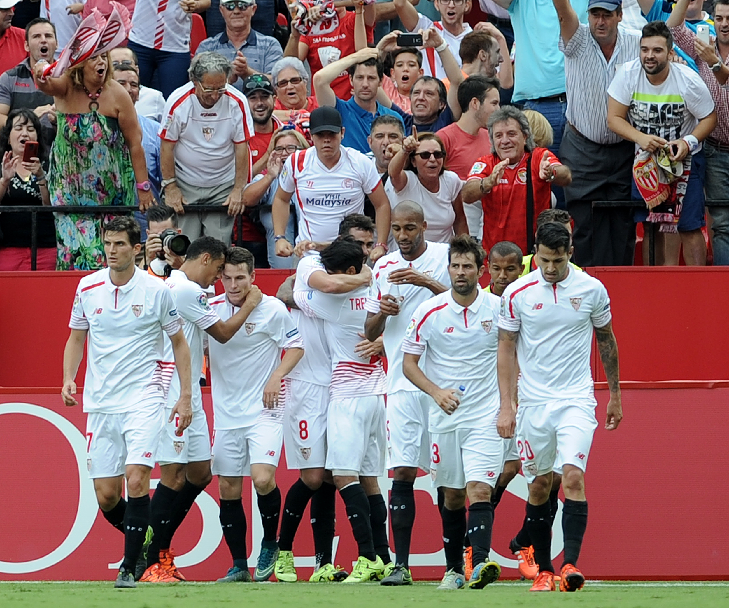 Sevilla's midfielder Iborra (C) celebrates after scoring during the Spanish league football match Sevilla FC vs Barcelona at the Ramon Sanchez Pizjuan stadium in Sevilla on October 3, 2015. AFP PHOTO/ CRISTINA QUICLER