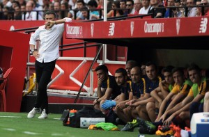 Barcelona's coach Luis Enrique (L) leans on the bench roof during the Spanish league football match Sevilla FC vs Barcelona at the Ramon Sanchez Pizjuan stadium in Sevilla on October 3, 2015. AFP PHOTO/ CRISTINA QUICLER