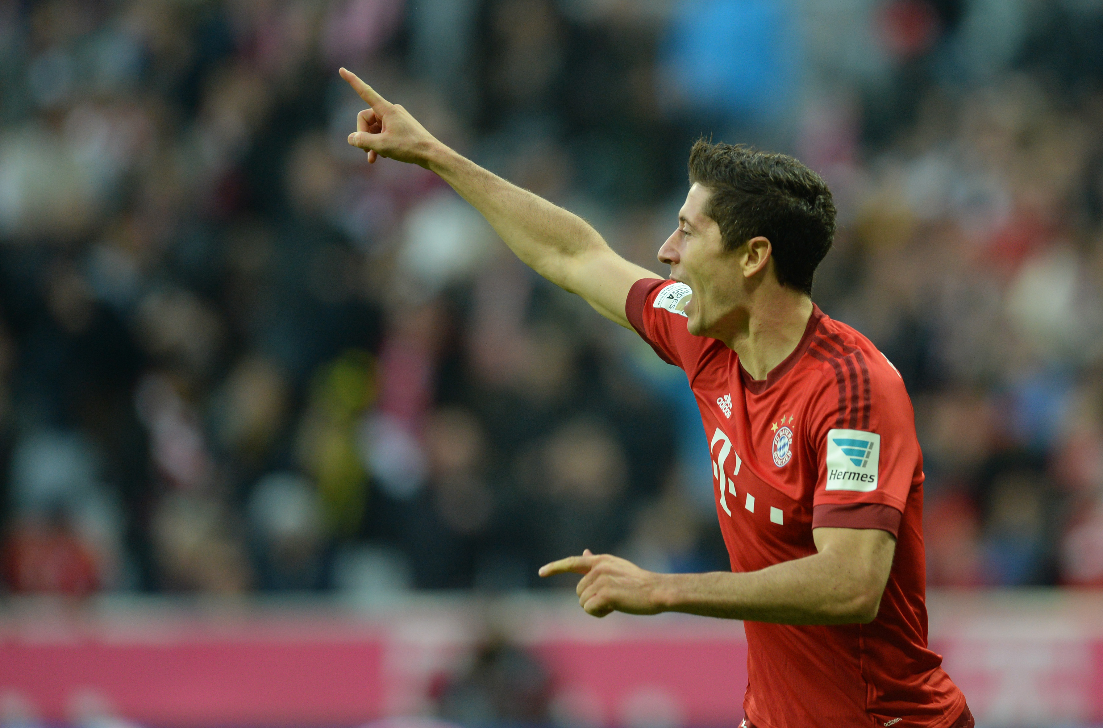 Bayern Munich's Polish striker Robert Lewandowski celebrates after he scores the second goal for Munich during the German first division Bundesliga football match FC Bayern Munich vs Borussia Dortmund in Munich, southern Germany, on October 4, 2015. AFP PHOTO / CHRISTOF STACHE RESTRICTIONS: DURING MATCH TIME: DFL RULES TO LIMIT THE ONLINE USAGE TO 15 PICTURES PER MATCH AND FORBID IMAGE SEQUENCES TO SIMULATE VIDEO. == RESTRICTED TO EDITORIAL USE == FOR FURTHER QUERIES PLEASE CONTACT DFL DIRECTLY AT + 49 69 650050.