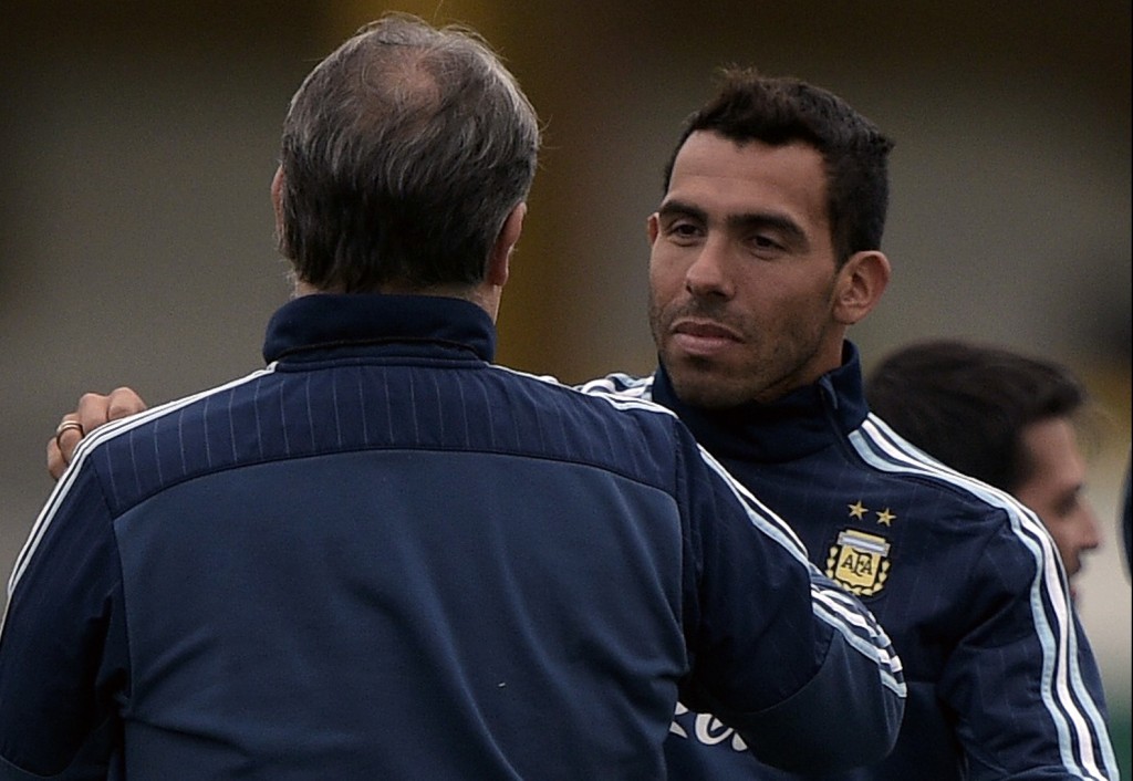 Argentina's forward Carlos Tevez (2-L) greets coach Gerardo Martino (L) during a training session in Ezeiza, Buenos Aires, on October 5, 2015 ahead of the 2018 FIFA World Cup Russia qualifier football match against Ecuador to be held in Buenos Aires on October 8.    AFP PHOTO / JUAN MABROMATA