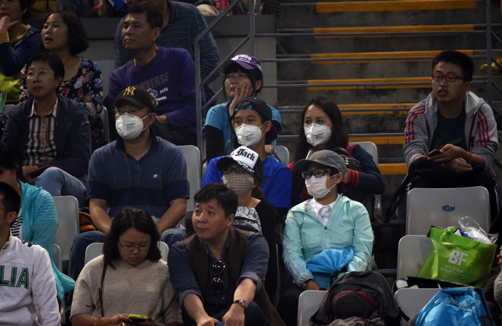 Torcedores se protegeram da poluição que atinge Pequim com máscaras (Foto: Wang Zhao/AFP)