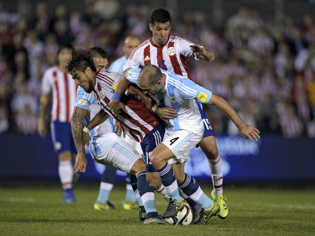 Argentina's defenders Nicolas Otamendi (L, back) and Pablo Zabaleta (R) vie with Paraguay's Dario Lezcano and Victor Javier Caceres (R, back) during their Russia 2018 FIFA World Cup South American Qualifiers football match, at the Defensores del Chaco stadium in Asuncion, on October 13, 2015.  AFP PHOTO / JUAN MABROMATA