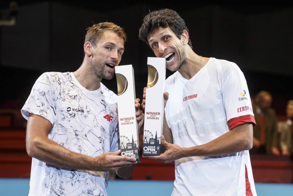 Marcelo Melo (dir.) e Lukasz Kubot comemoram o título com a tradicional mordida nos troféus (Foto: Vienna Open/Divulgação)