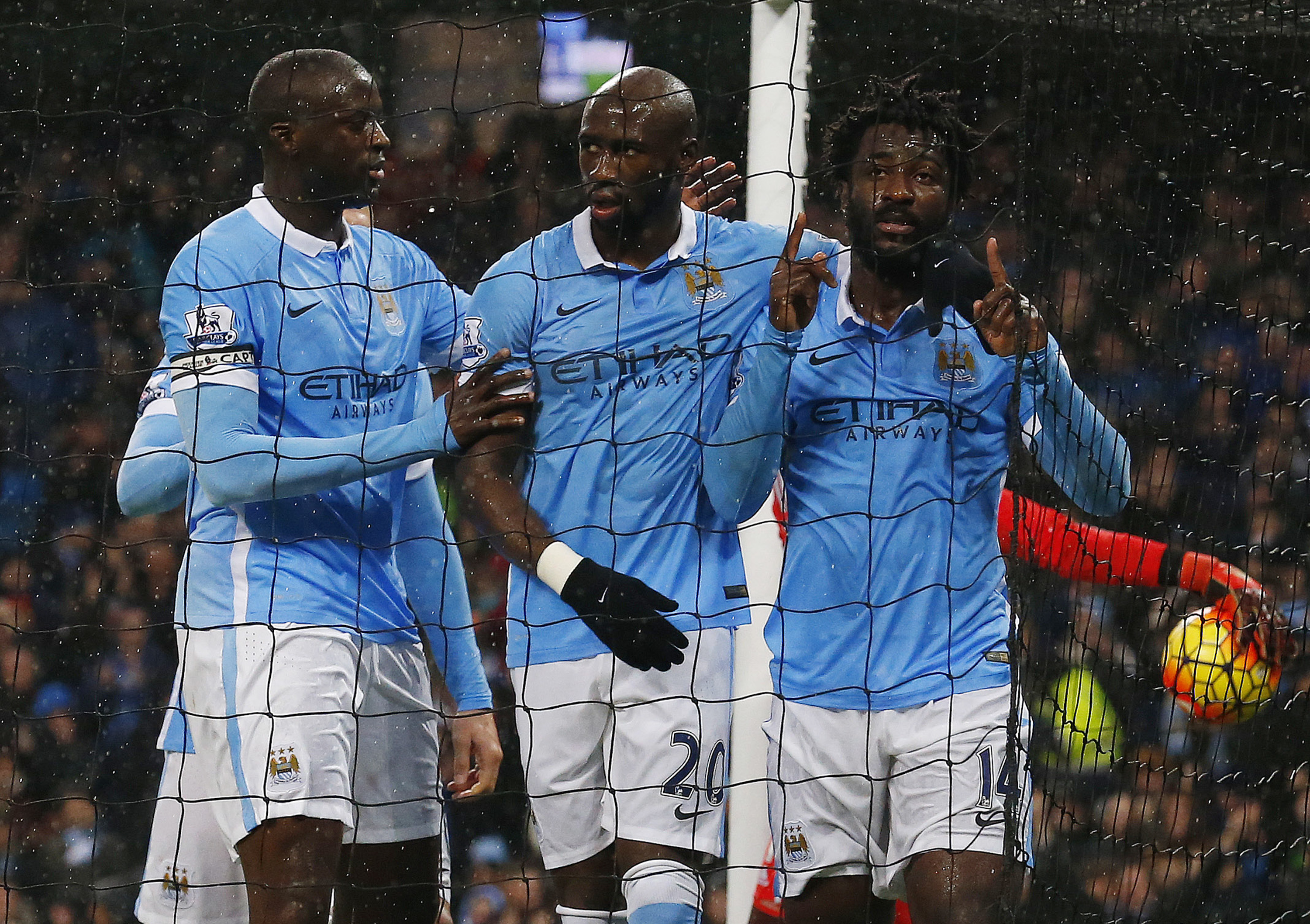 Manchester City's Ivorian striker Wilfried Bony (R) celebrates scoring the opening goal with Manchester City's Ivorian midfielder and captain Yaya Toure (L) and Manchester City's French defender Eliaquim Mangala (C) during the English Premier League football match between Manchester City and Swansea City at the Etihad Stadium in Manchester, north west England, on December 12, 2015. AFP PHOTO / LINDSEY PARNABY RESTRICTED TO EDITORIAL USE. No use with unauthorized audio, video, data, fixture lists, club/league logos or 'live' services. Online in-match use limited to 75 images, no video emulation. No use in betting, games or single club/league/player publications. / AFP / LINDSEY PARNABY