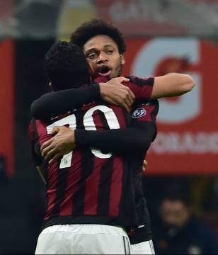 AC Milan's forward from Colombia Carlos Bacca celebrates with AC Milan's forward from Brazil Luiz Adriano after scoring a goal during the Italian Seria A football match AC Milan vs Hellas Verona at San Siro Stadium in Milan on December 13, 2015. AFP PHOTO / GIUSEPPE CACACE / AFP / GIUSEPPE CACACE