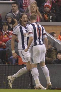 West Bromwich Albion's Swedish defender Jonas Olsson (L) celebrates scoring their second goal during the English Premier League football match between Liverpool and West Bromwich Albion at Anfield in Liverpool, northwest England, on December 13, 2015.  AFP PHOTO / OLI SCARFF RESTRICTED TO EDITORIAL USE. No use with unauthorized audio, video, data, fixture lists, club/league logos or 'live' services. Online in-match use limited to 75 images, no video emulation. No use in betting, games or single club/league/player publications. / AFP / OLI SCARFF