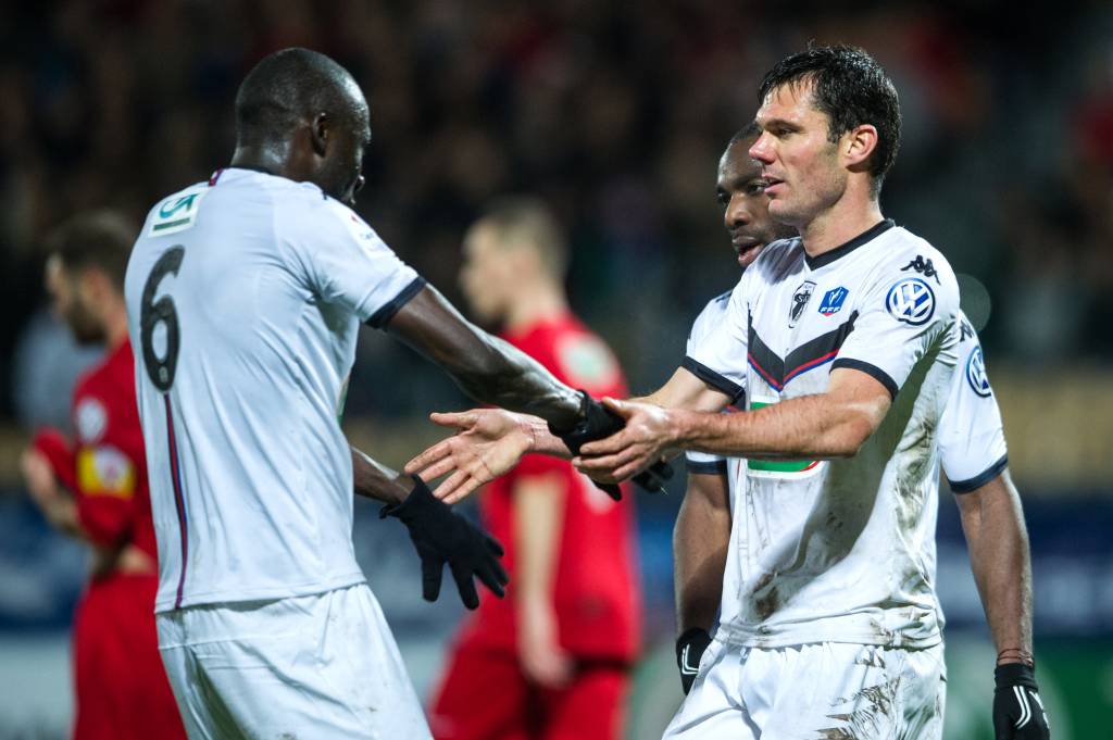 Angers' French midfielder Charles Diers (R) is congratulated by Angers' Senegalese midfielder Cheikh Ndoye (L) after scoring a goal during the French cup round of 64 football match between Besancon (RB) and Angers (ASCO) at the Leo Lagrange Stadium in Besancon, on January 2, 2016.  / AFP / SEBASTIEN BOZON