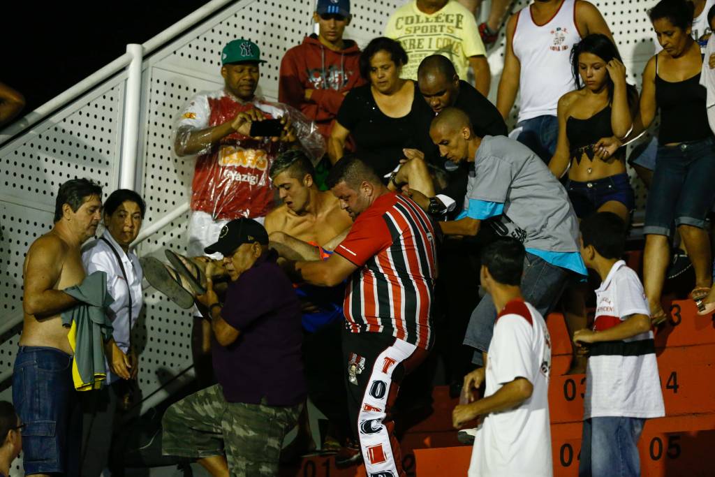Torcedor foi retirado das arquibancadas passando mal em meio à confusão (Foto: Marcello Zambrana/AGIF/Gazeta Press)