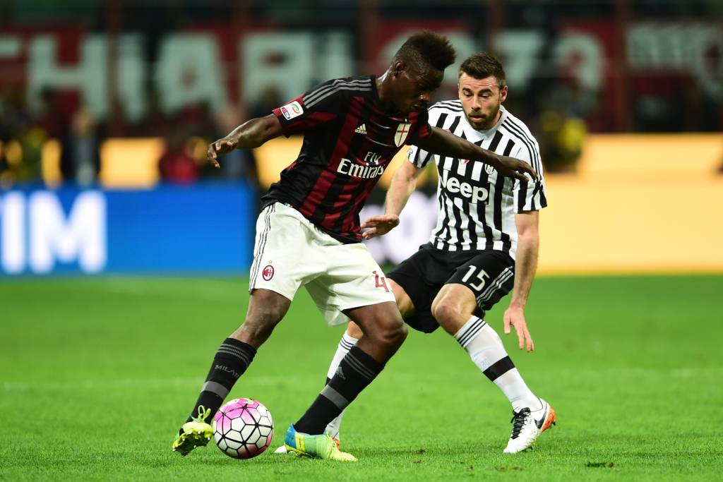 Juventus' defender from Italy Andrea Barzagli (R) fights for the ball with AC Milan's forward from Italy Mario Balotelli  during the Italian Serie A football match AC Milan' vs Juventus  at "San Siro" Stadium in Milan on April 9, 2016. / AFP PHOTO / GIUSEPPE CACACE