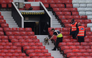 A sniffer dog searches the stands after fans evacuated Old Trafford stadium in Manchester, north west England, on May 15, 2016, after the English Premier League football match between Manchester United and Bournemouth was abandoned. Police ordered Manchester United to abandon their final Premier League game of the season against Bournemouth on Sunday after a suspicious package was discovered at Old Trafford. / AFP PHOTO / OLI SCARFF / RESTRICTED TO EDITORIAL USE. No use with unauthorized audio, video, data, fixture lists, club/league logos or 'live' services. Online in-match use limited to 75 images, no video emulation. No use in betting, games or single club/league/player publications.  /