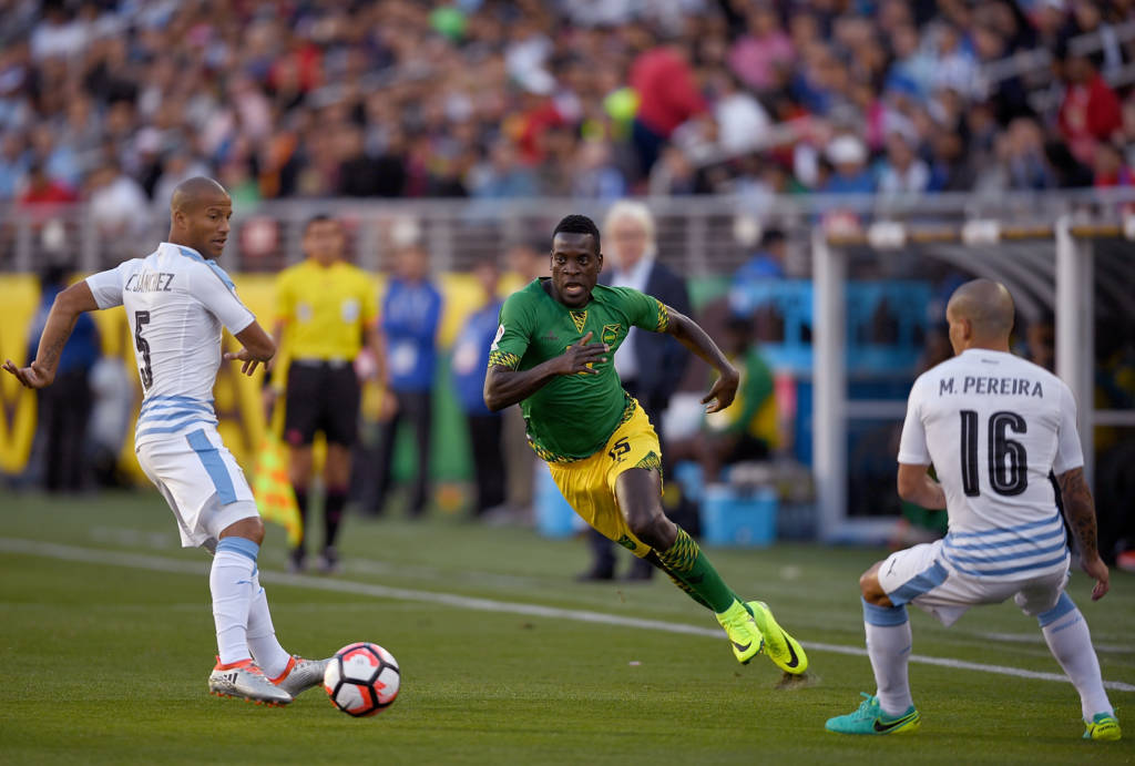 SANTA CLARA, CA - JUNE 13: JeVaughn Watson #15 of Jamaica dribbles the ball up field past Carlos Sanchez #5 and Maximiliano Pereira #16 of Uruguay during the 2016 Copa America Centenario Group match play between Uruguay and Jamaica at Levi's Stadium on June 13, 2016 in Santa Clara, California.   Thearon W. Henderson/Getty Images/AFP
