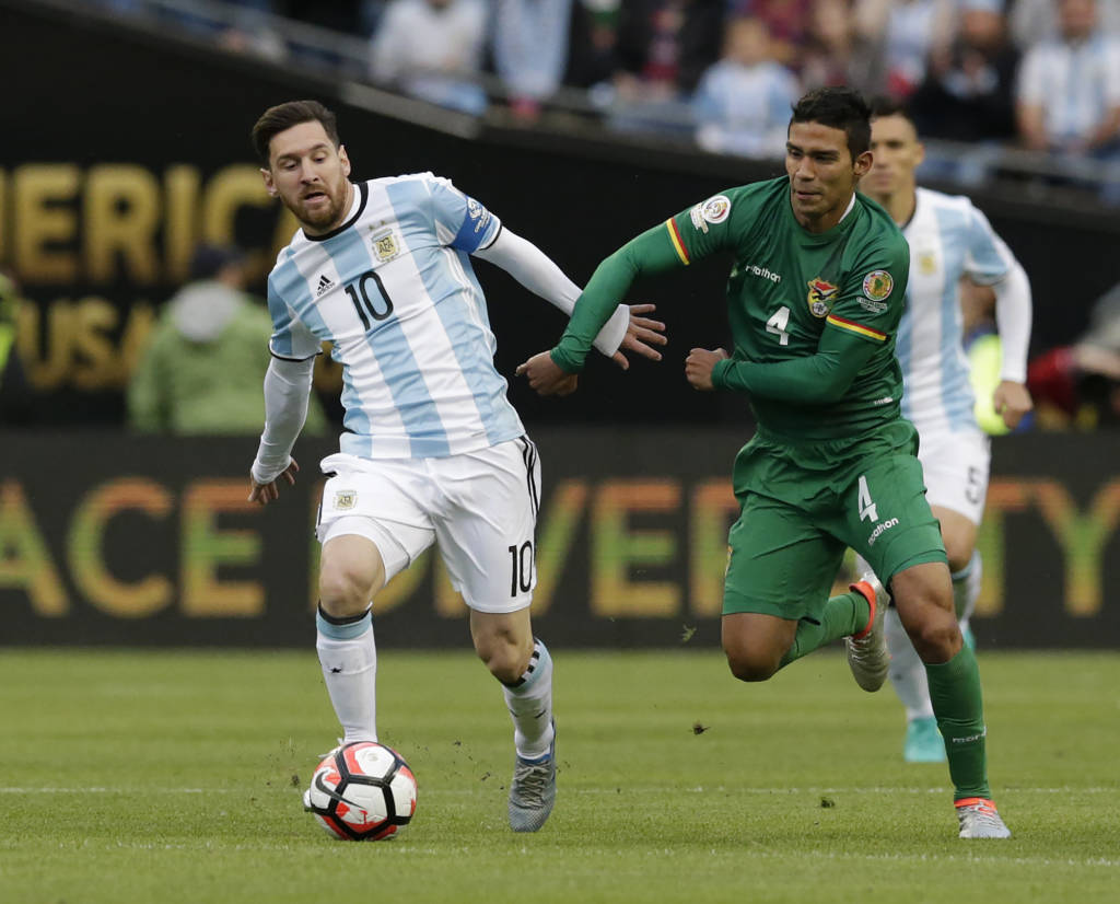 Argentina's Lionel Messi (L) is marked by Bolivia's Diego Bejarano during their Copa America Centenario football tournament match in Seattle, Washington, United States, on June 14, 2016. / AFP PHOTO / Jason REDMOND