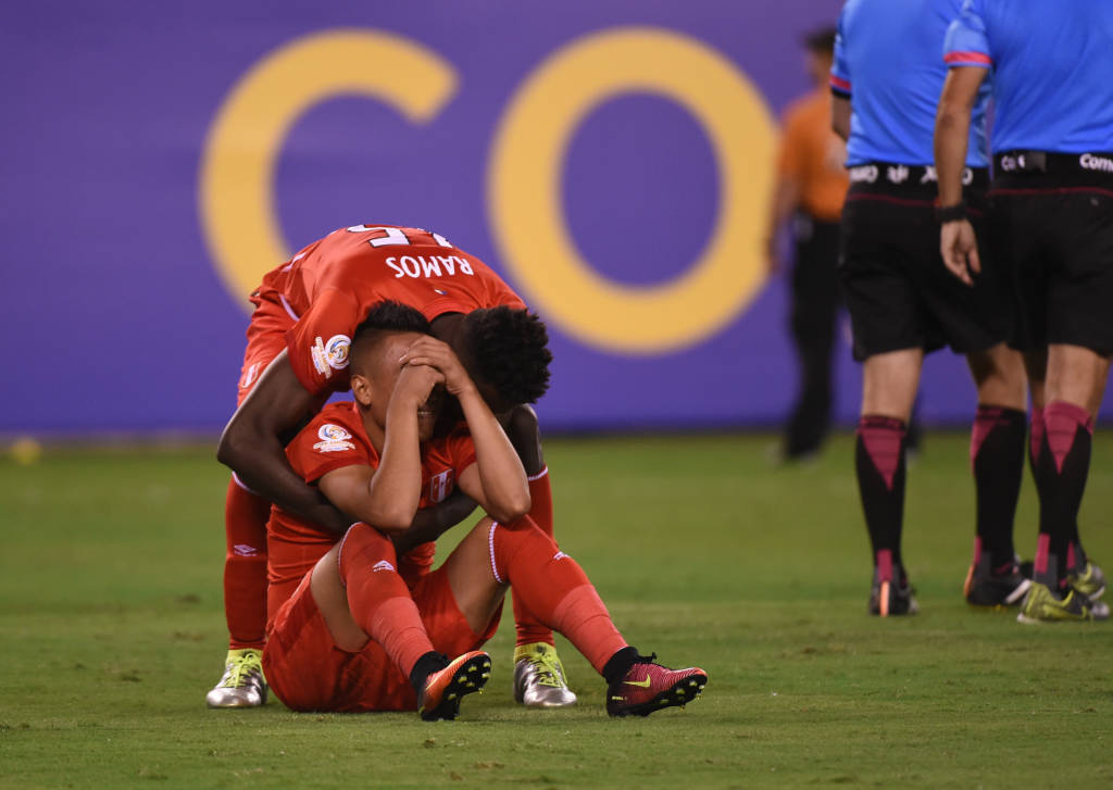 Peru's Christian Cueva (sitting on ground) cries inconsolably after missing his shot in the penalty shoot-out against Colombia and being thrown out of the Copa America Centenario in their quarterfinal football match, in East Rutherford, New Jersey, United States, on June 17, 2016. / AFP PHOTO / Timothy A. CLARY