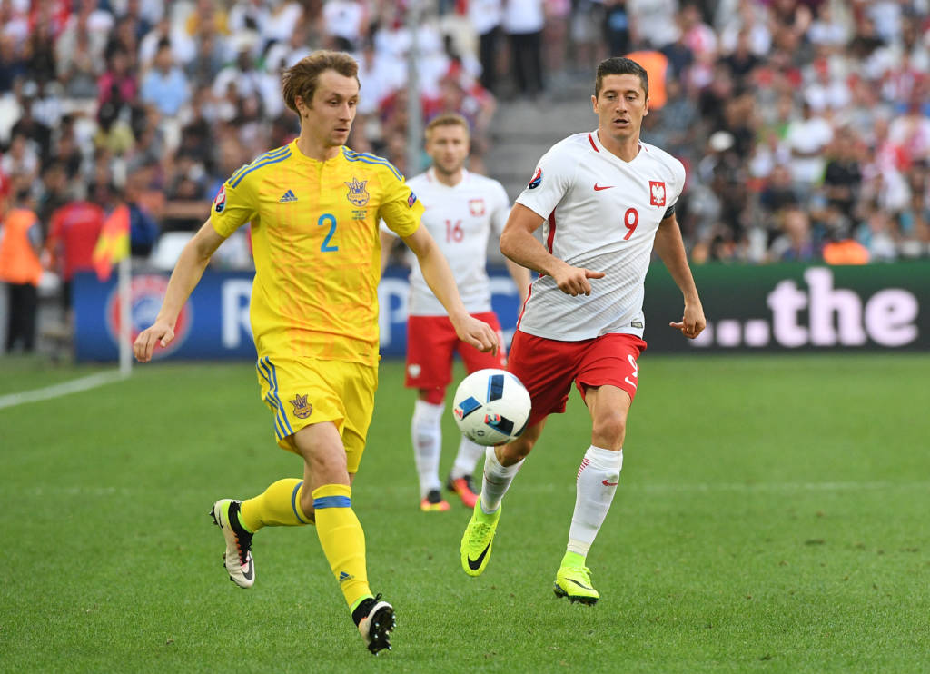 O zagueiro ucraniano Butko disputa a bola com o atacante polonês Robert Lewandowski (Foto: Vincenzo Pinto/AFP)