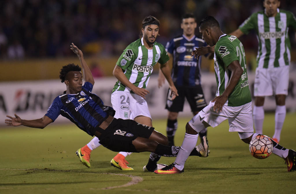 Colombia's Atletico Nacional Orlando Berrio (L) vies for the ball with Ecuador's Independiente del Valle Jefferson Orejuela during the Copa Libertadores first leg football final, at the Atahualpa stadium in Quito on July 20, 2016. / AFP PHOTO / RODRIGO BUENDIA