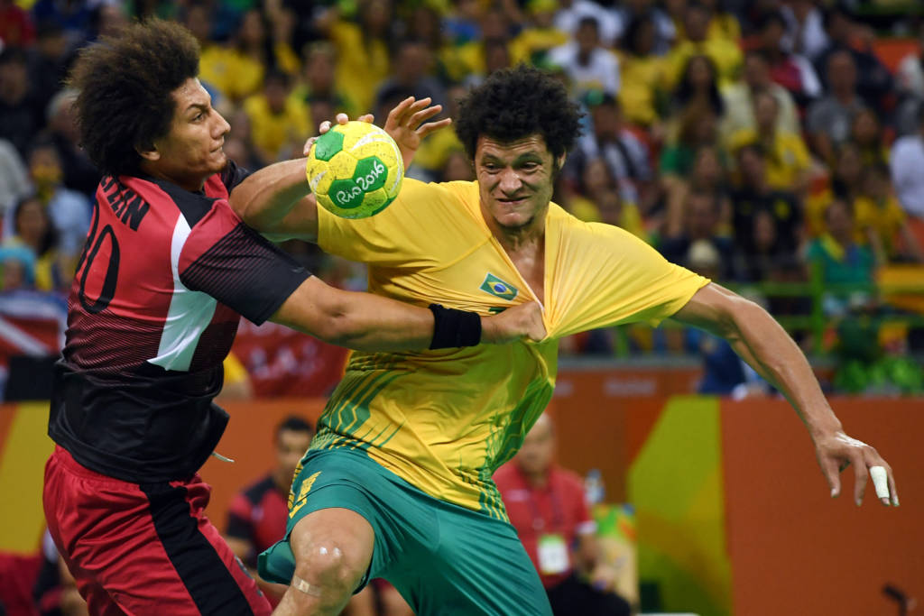 Brazil's left wing Thiagus dos Santos (R) vies with Egypt's left back Ali Mohamed during the men's preliminaries Group B handball match Egypt vs Brazil for the Rio 2016 Olympics Games at the Future Arena in Rio on August 13, 2016. / AFP PHOTO / Roberto SCHMIDT