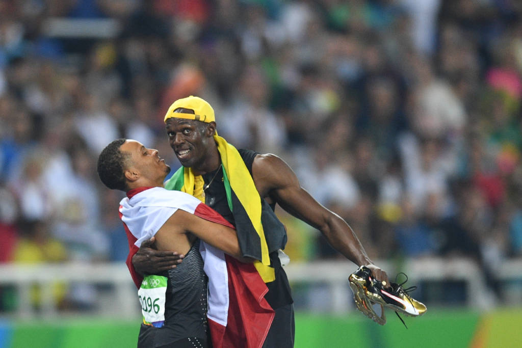 Abraçado a Andre De Grasse, medalhista de bronze, Bolt não largou as sapatilhas (foto: Johannes Eisele/AFP)