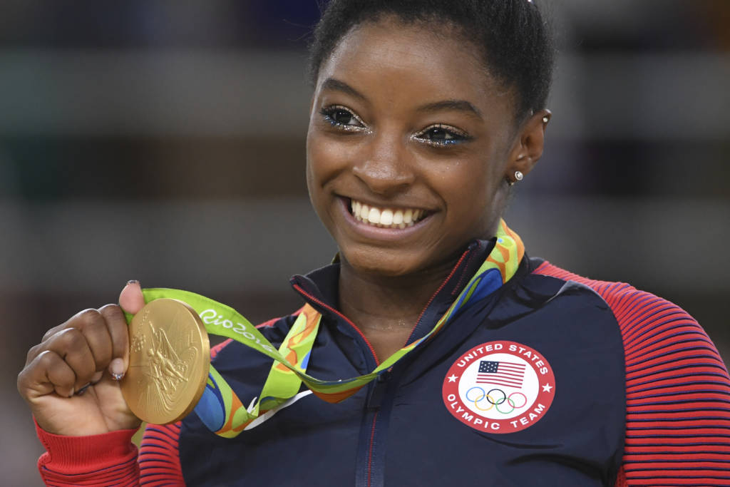 US gymnast Simone Biles celebrates on the podium of the women's floor event final of the Artistic Gymnastics at the Olympic Arena during the Rio 2016 Olympic Games in Rio de Janeiro on August 16, 2016. / AFP PHOTO / Toshifumi KITAMURA