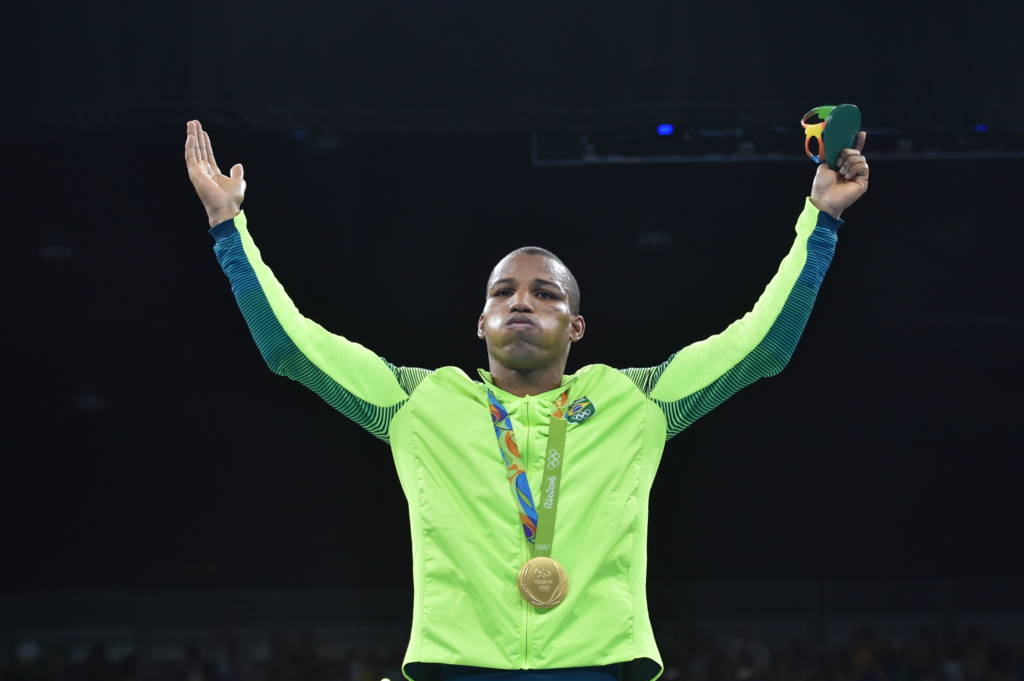 Brazil's Robson Conceicao poses with a gold medal at the Rio 2016 Olympic Games in Rio de Janeiro on August 16, 2016. Robson Conceicao made history for the hosts when he won Brazil's first-ever Olympic boxing gold in Rio, triggering pandemonium. The man who sold vegetables on the streets as an impoverished child became an instant national hero in defeating the Frenchman Sofiane Oumiha on unanimous points in their lightweight final showdown. / AFP PHOTO / YURI CORTEZ