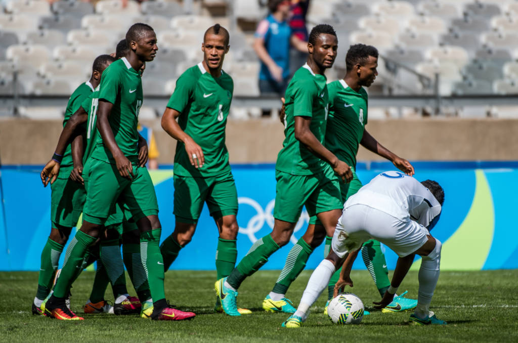 Nigeria's players celebrate after teammate Umar Aminu (covered) scored against Honduras during the Rio 2016 Olympic Games men's bronze medal football match at the Mineirao stadium in Belo Horizonte, Brazil, on August 20, 2016.  / AFP PHOTO / GUSTAVO ANDRADE