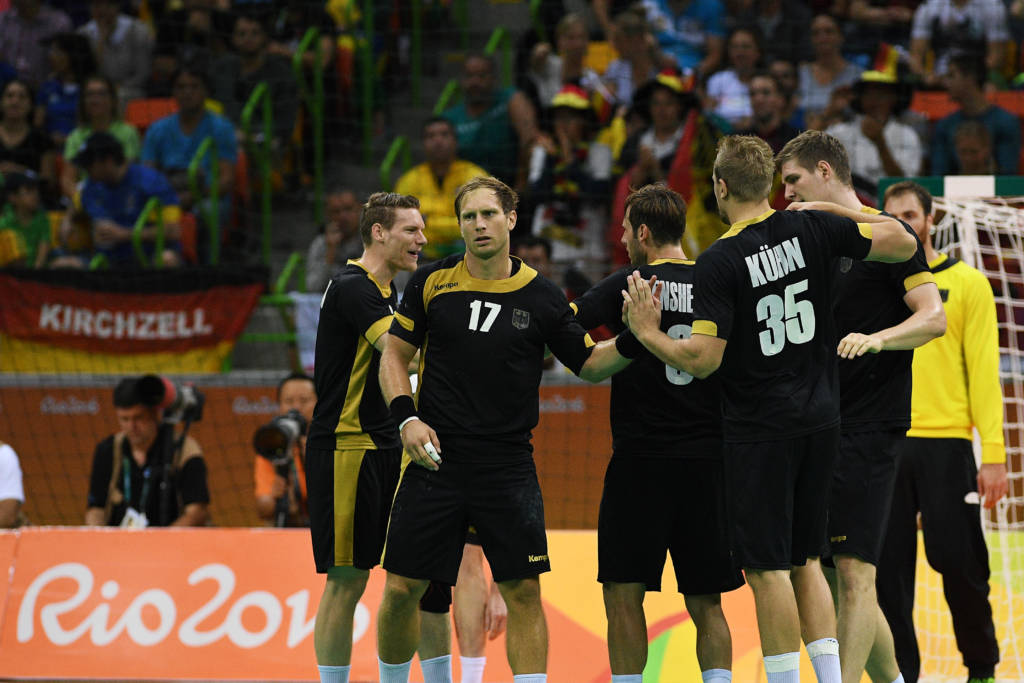 Germany's right back Steffen Weinhold (2ndL) and teammates celebrate a goal during the men's Bronze Medal handball match Poland vs Germany for the Rio 2016 Olympics Games at the Future Arena in Rio on August 21, 2016. / AFP PHOTO / Roberto SCHMIDT