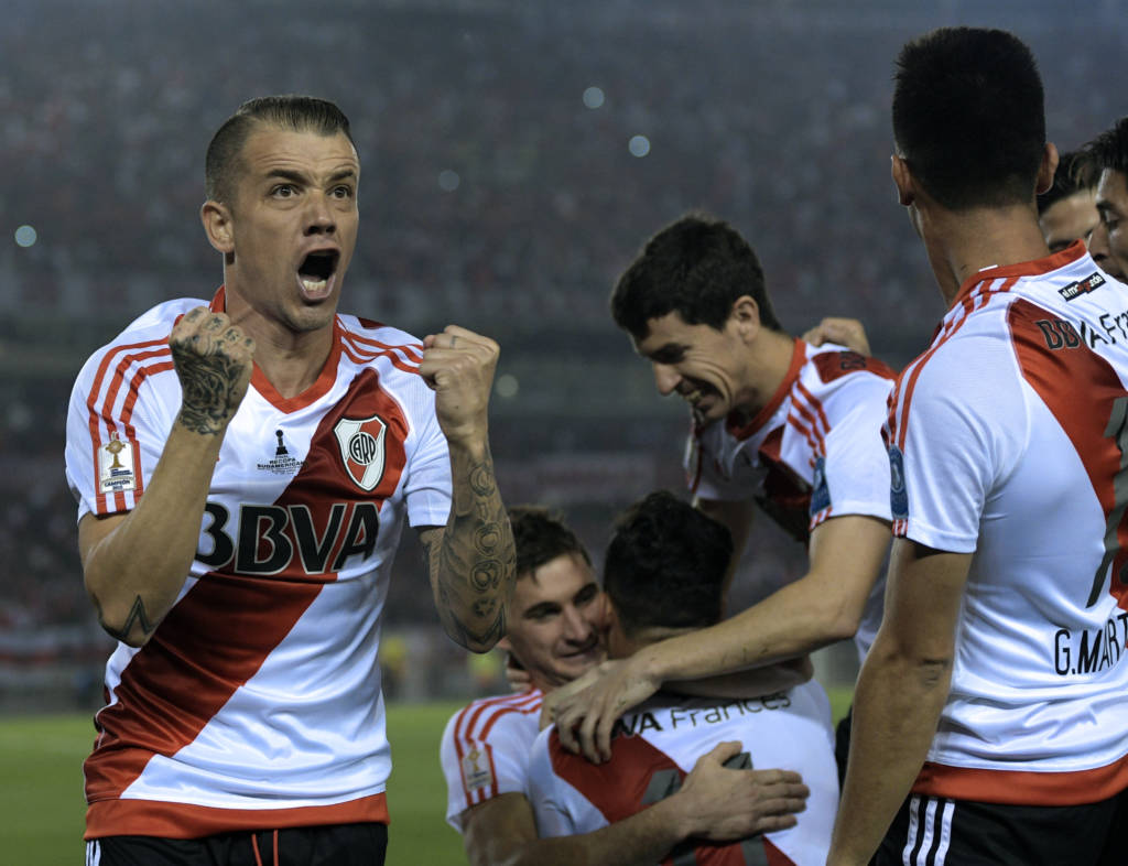 Argentina's River Plate midfielder Andres D'Alessandro (L) celebrates with teammates after forward Sebastian Driussi (C, bottom) scored a goal against Colombia's Independiente Santa Fe during their Recopa Sudamericana 2016 second leg final football match at the Monumental stadium in Buenos Aires on August 25, 2016. / AFP PHOTO / JUAN MABROMATA