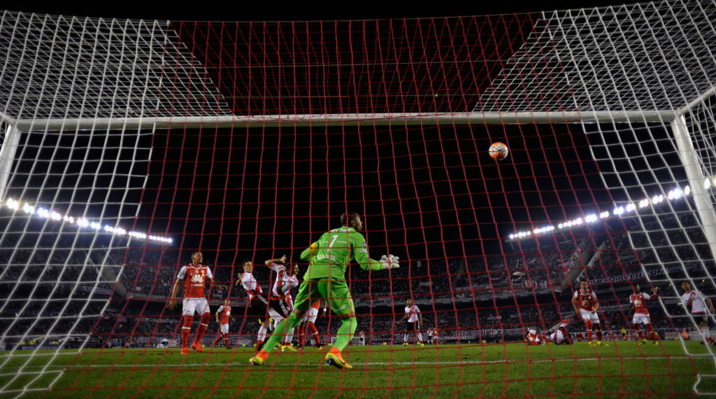 Argentina's River Plate forward Lucas Alario (C) heads the ball to score the team's second goal against Colombia's Independiente Santa Fe during their Recopa Sudamericana 2016 second leg final football match at the Monumental stadium in Buenos Aires on August 25, 2016. / AFP PHOTO / ALEJANDRO PAGNI