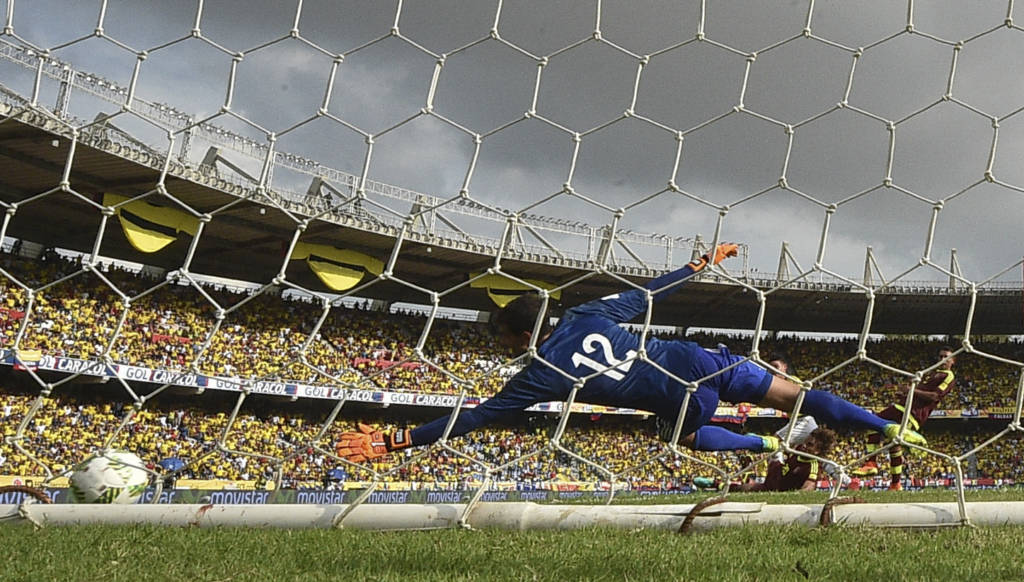 O goleiro da Venezuela, Daniel Hernández, pula inutilmente em arremate de James Rodríguez (Foto: Luis Acosta/AFP)