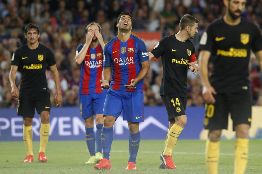 Barcelona's Uruguayan forward Luis Suarez (C) gestures after missing a goal opportunity during the Spanish league football match FC Barcelona vs Atletico de Madrid at the Camp Nou stadium in Barcelona on September 21, 2016. / AFP PHOTO / PAU BARRENA