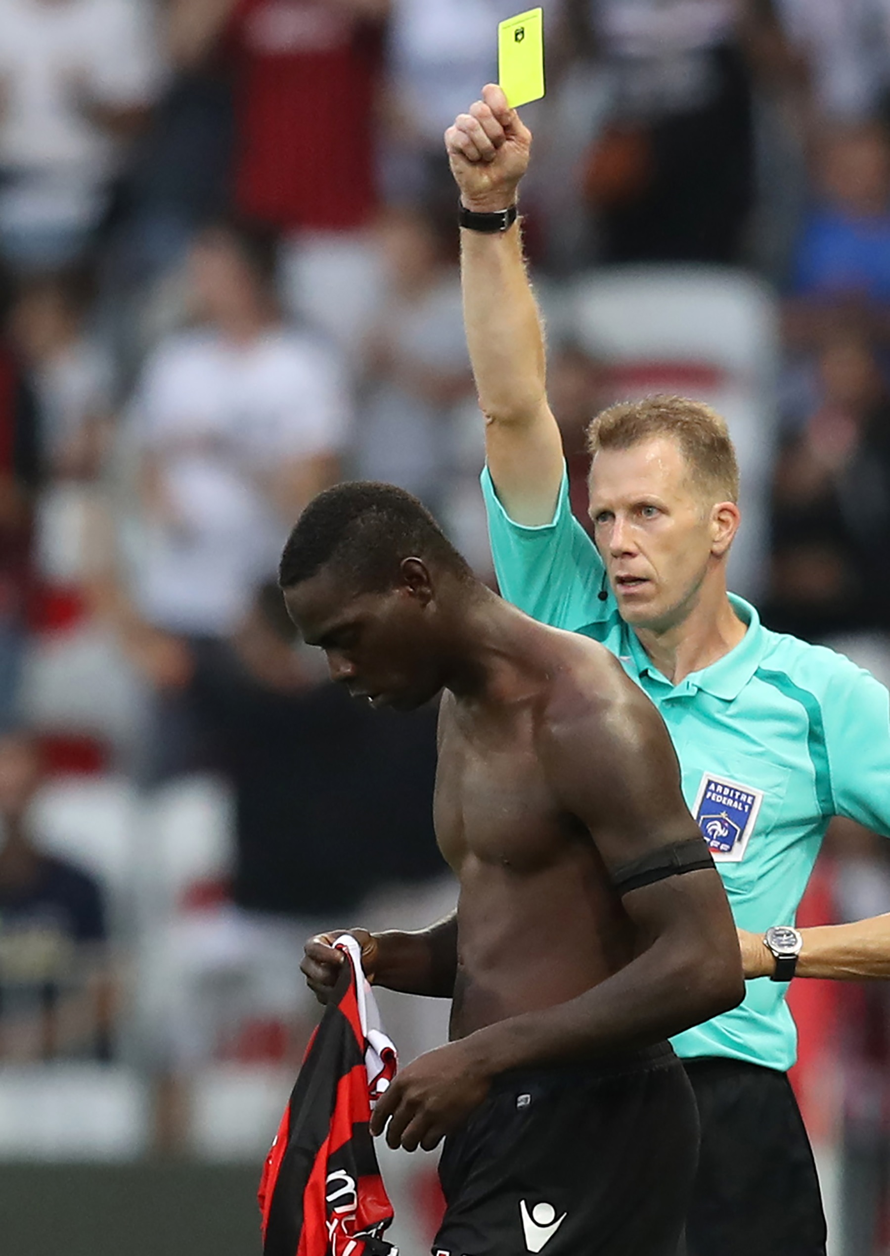Balotelli recebeu o primeiro cartão amarelo após tirar a camisa durante a comemoração de seu gol (Foto: VALERY HACHE/AFP)