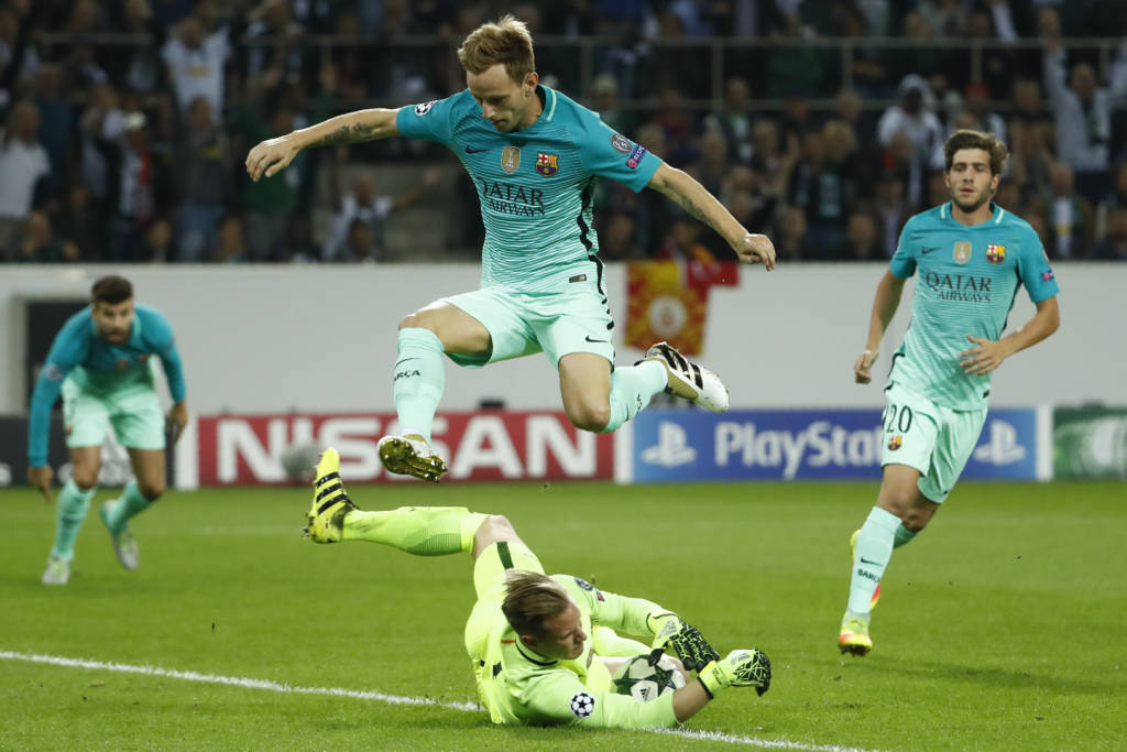 Barcelona's Croatian midfielder Ivan Rakitic jumps over Barcelona's German goalkeeper Marc-Andre Ter Stegen who caught the ball during the UEFA Champions League first-leg group C football match between Borussia Moenchengladbach and FC Barcelona at the Borussia Park in Moenchengladbach, western Germany on September 28, 2016. / AFP PHOTO / Odd ANDERSEN