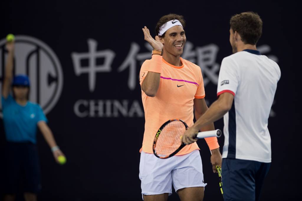 Rafael Nadal of Spain (L) celebrates winning a point with Pablo Carreno Busta of Spain (R) during their men's doubles first round match against Rohan Bopanna of India and Daniel Nestor of Canada at the China Open tennis tournament in Beijing on October 3, 2016. / AFP PHOTO / NICOLAS ASFOURI