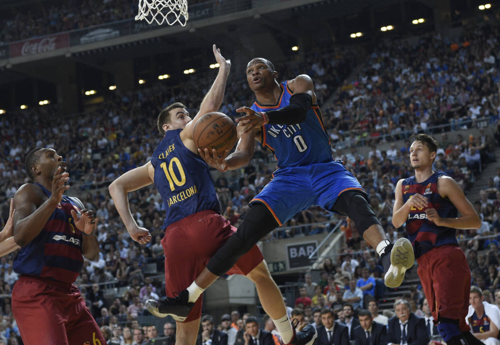 Oklahoma's guard Russell Westbrook (R) vies with Barcelona's forward Victor Claver (L) during the NBA Global Games Europe 2016 basketball match between FC Barcelona Lassa and Oklahoma City Thunder at Palau Sant Jordi in Barcelona on October 5, 2016. / AFP PHOTO / LLUIS GENE