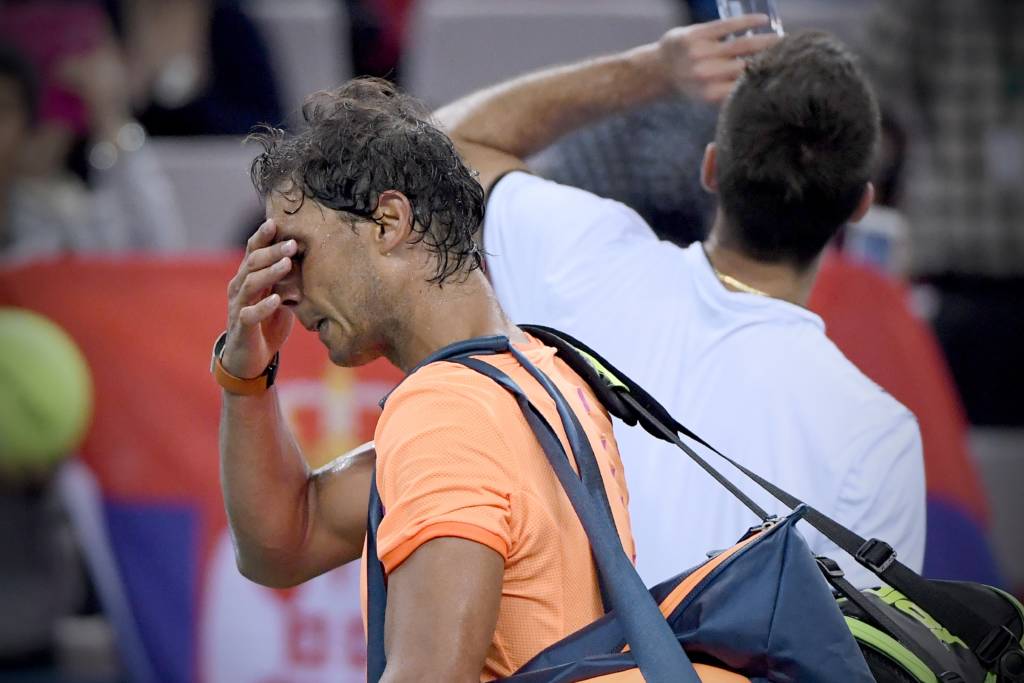 Rafael Nadal of Spain (L) walks past Viktor Troicki of Serbia (R) after their men's singles match at the Shanghai Masters tennis tournament in Shanghai on October 12, 2016. / AFP PHOTO / WANG ZHAO
