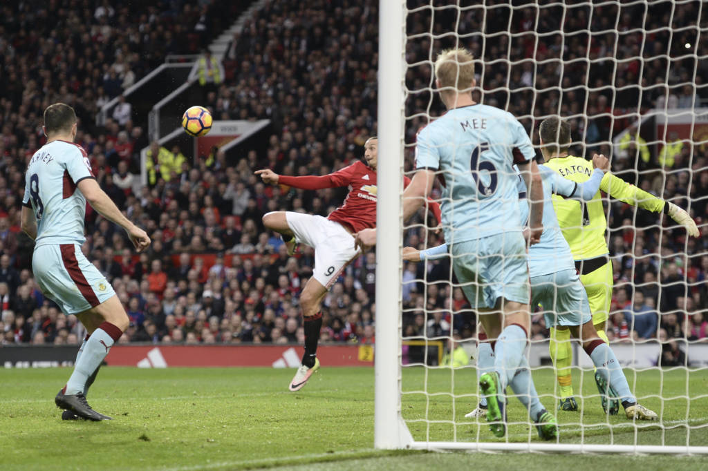 Manchester United's Swedish striker Zlatan Ibrahimovic (C) volleys the ball to draw a save from Burnley's English goalkeeper Tom Heaton (R) during the English Premier League football match between Manchester United and Burnley at Old Trafford in Manchester, north west England, on October 29, 2016. / AFP PHOTO / OLI SCARFF / RESTRICTED TO EDITORIAL USE. No use with unauthorized audio, video, data, fixture lists, club/league logos or 'live' services. Online in-match use limited to 75 images, no video emulation. No use in betting, games or single club/league/player publications.  /