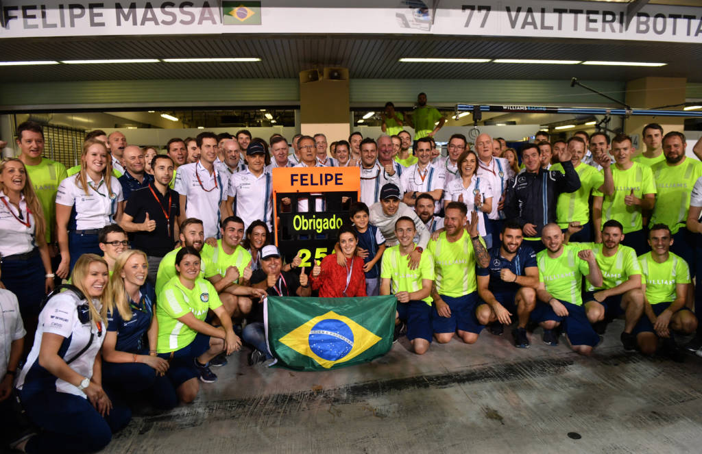 Williams Martini Racing's team members pose for a picture before greeting Brazilian driver Felipe Massa at the end of the Abu Dhabi Formula One Grand Prix at the Yas Marina circuit on November 27, 2016. The Abu Dhabi Grand Prix was Massa's last race before his retirement. Nico Rosberg won his maiden Formula One world title by securing second place behind his Mercedes arch-rival Lewis Hamilton in the Abu Dhabi Grand Prix. / AFP PHOTO / Andrej ISAKOVIC