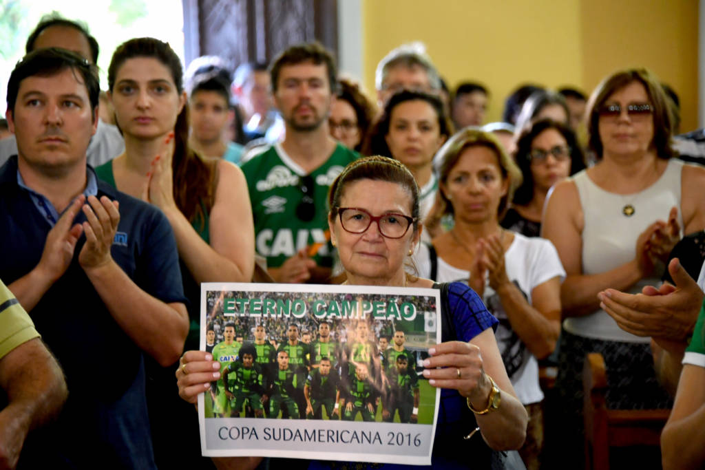 People attend a mass in memoriam of the players of Brazilian team Chapecoense Real killed in a plane crash in the Colombian mountains, in Chapeco, in the southern Brazilian state of Santa Catarina, on November 29, 2016. Players of the Chapecoense were among 81 people on board the doomed flight that crashed into mountains in northwestern Colombia, in which officials said just six people were thought to have survived, including three of the players. Chapecoense had risen from obscurity to make it to the Copa Sudamericana finals scheduled for Wednesday against Atletico Nacional of Colombia. / AFP PHOTO / Nelson Almeida