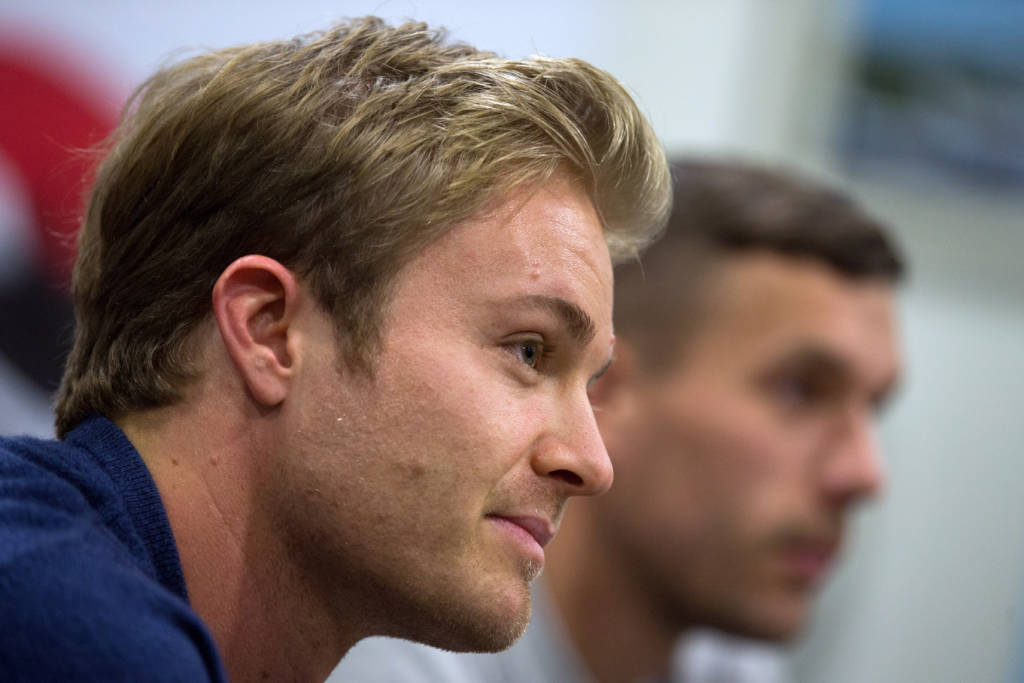 Formula One World Champion Nico Rosberg (L) and former German player Lukas Podolski speak to journalists at the airport in Cologne, western Germany on December 7, 2016. / AFP PHOTO / dpa / Rolf Vennenbernd / Germany OUT